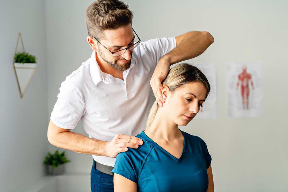 A doctor working on curing neck pain of a female patient