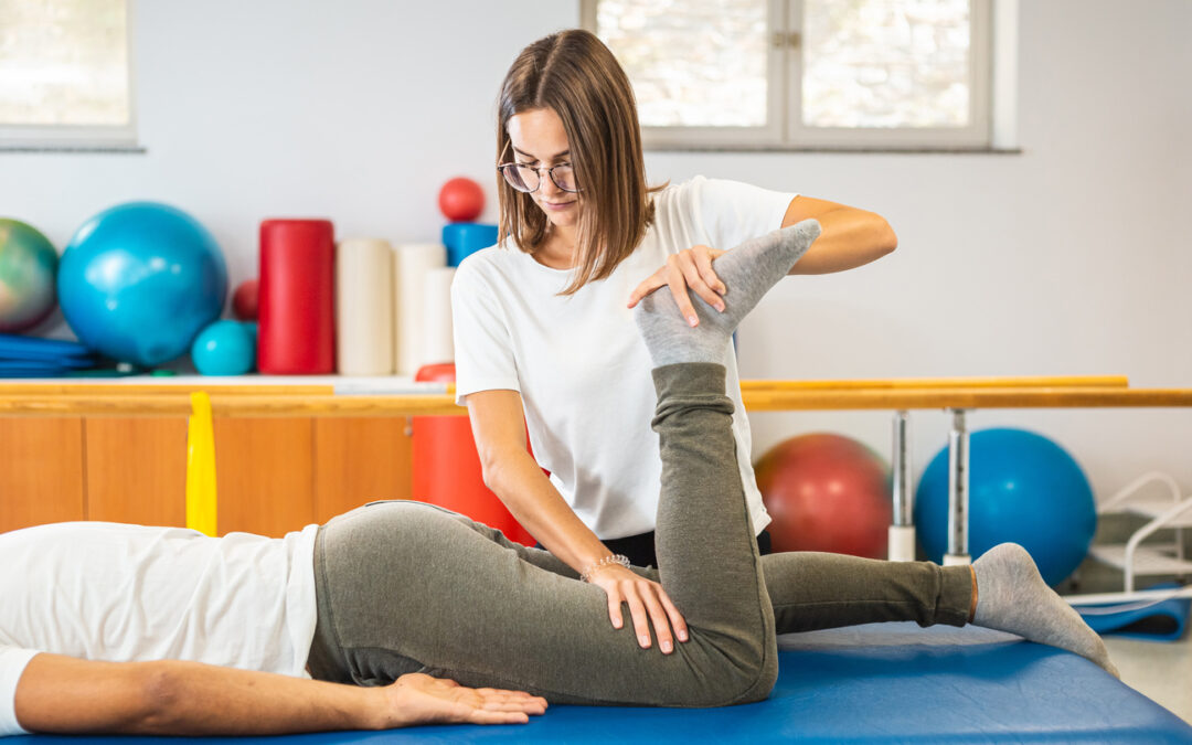 Female chiropractor doing leg stretching exercises with a male patient